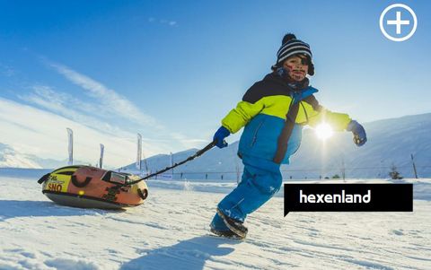 Ein Junge zieht einen Schneereifen die Piste entlang